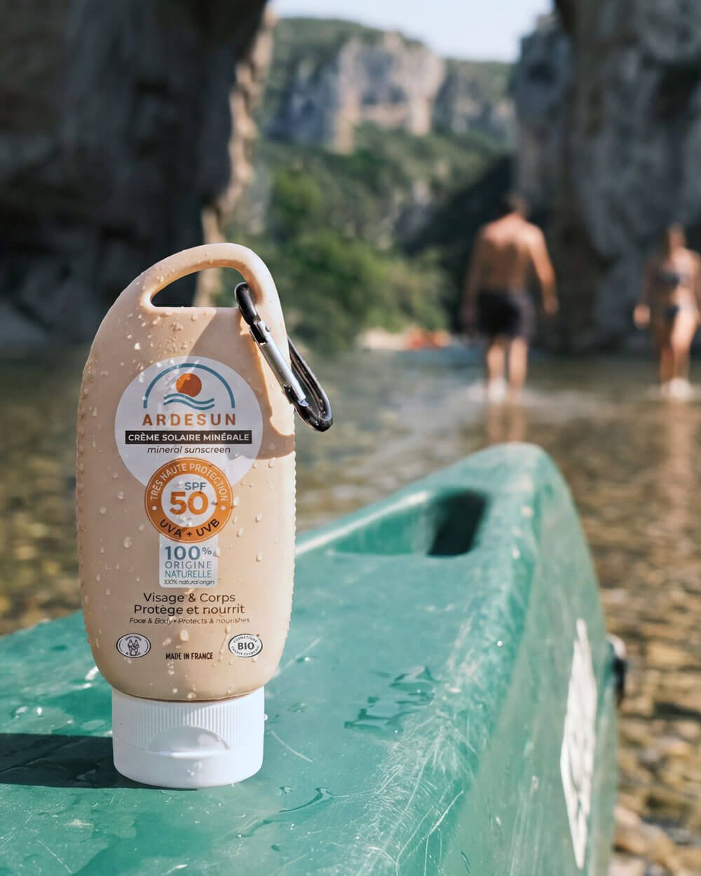 Crème solaire minérale SPF 50 ARDESUN posée sur un canoë au bord de l’eau, protection solaire pour activités outdoor